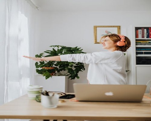 Mujer haciendo una pausa activa en su escritorio durante el home office